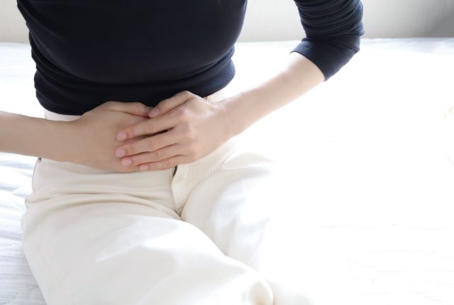 腹痛を起こしている女性