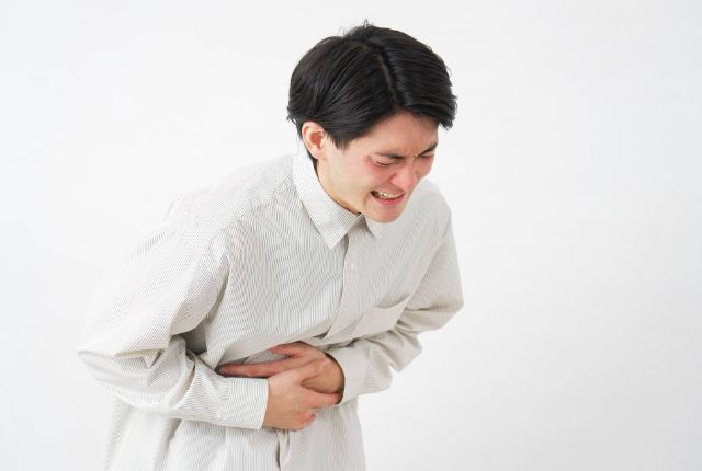 腹痛を起こしている男性