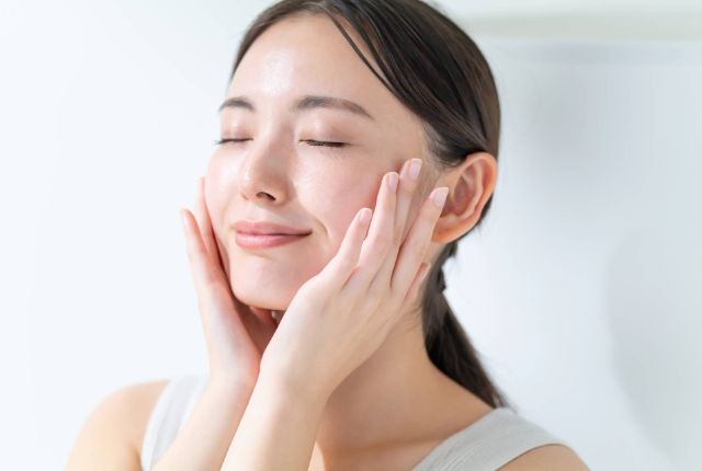 頬に手を当て微笑む女性